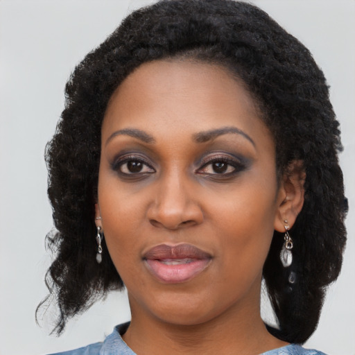 Joyful black young-adult female with long  black hair and brown eyes