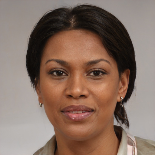 Joyful black adult female with medium  brown hair and brown eyes