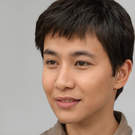 Joyful asian young-adult male with short  brown hair and brown eyes