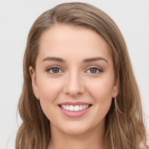 Joyful white young-adult female with long  brown hair and grey eyes