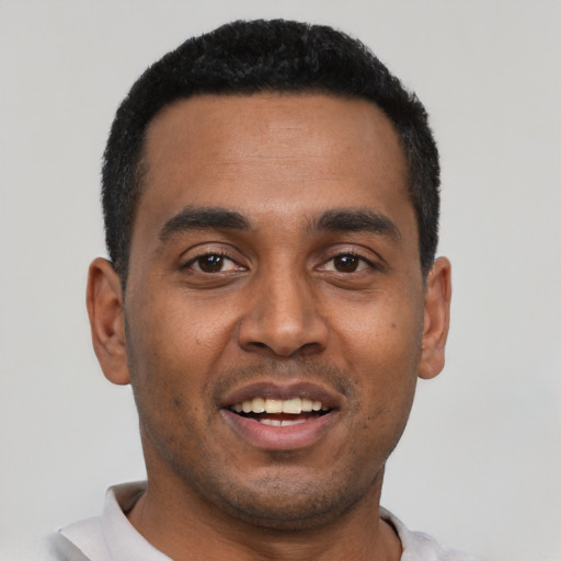 Joyful black young-adult male with short  black hair and brown eyes