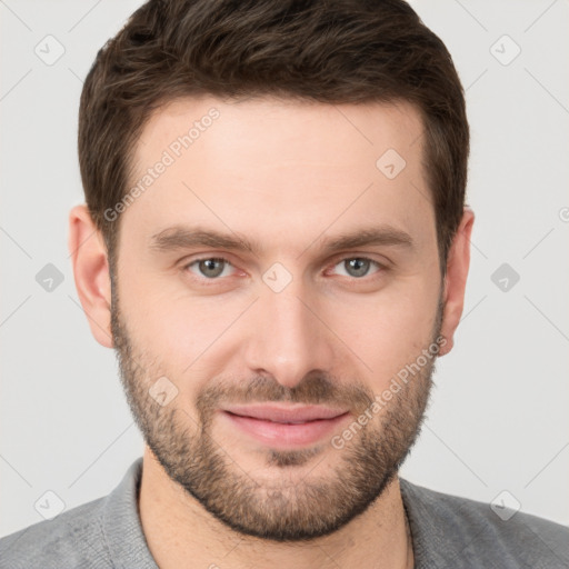 Joyful white young-adult male with short  brown hair and grey eyes