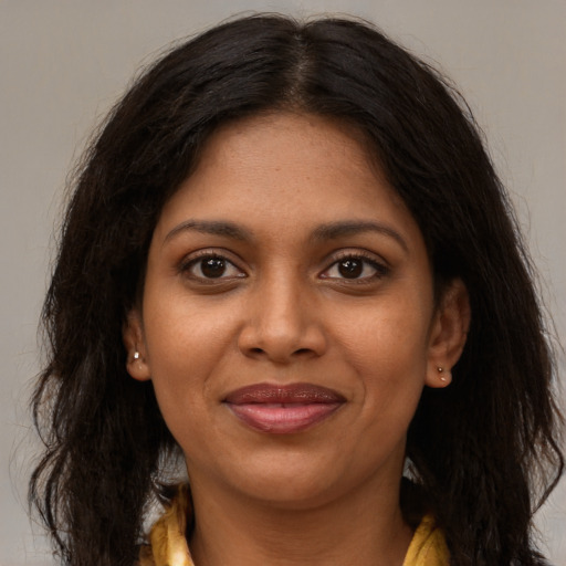 Joyful black young-adult female with long  brown hair and brown eyes