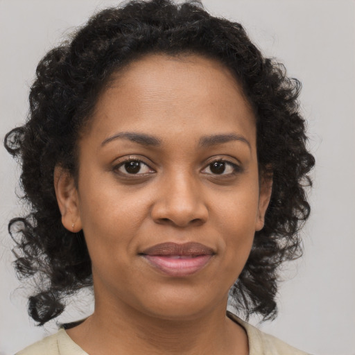 Joyful black young-adult female with medium  brown hair and brown eyes