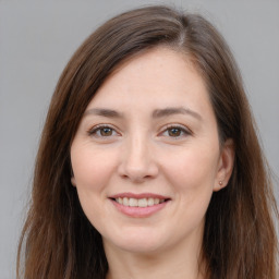 Joyful white young-adult female with long  brown hair and brown eyes