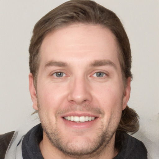 Joyful white adult male with short  brown hair and grey eyes