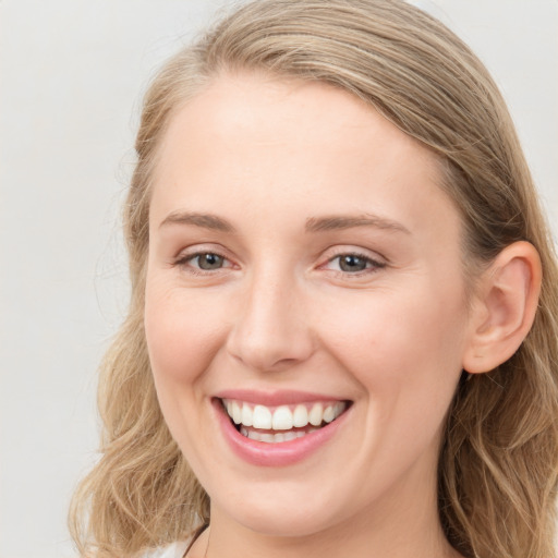 Joyful white young-adult female with long  brown hair and blue eyes