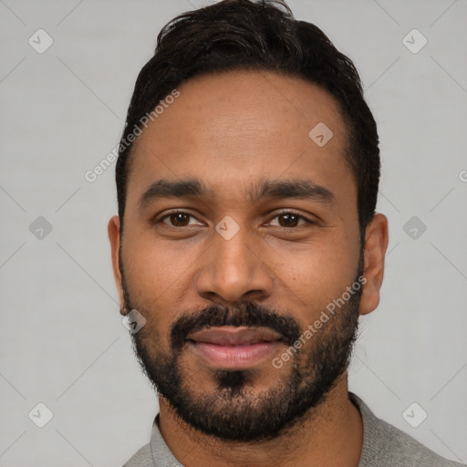 Joyful black young-adult male with short  black hair and brown eyes