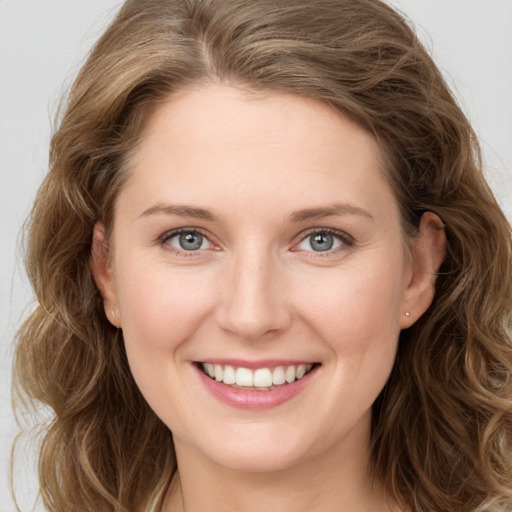 Joyful white young-adult female with long  brown hair and grey eyes