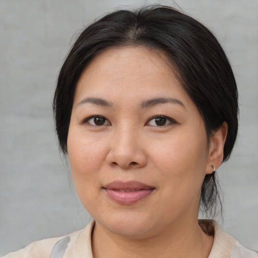 Joyful asian young-adult female with medium  brown hair and brown eyes