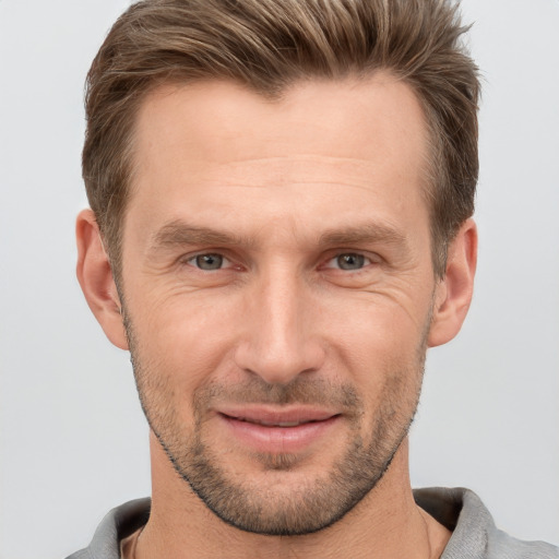 Joyful white adult male with short  brown hair and grey eyes