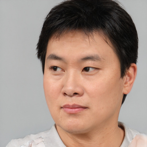 Joyful asian young-adult male with short  brown hair and brown eyes