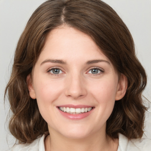 Joyful white young-adult female with medium  brown hair and green eyes