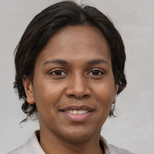 Joyful latino adult female with short  brown hair and brown eyes