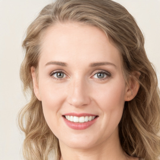 Joyful white young-adult female with long  brown hair and blue eyes