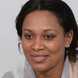 Joyful black adult female with medium  brown hair and brown eyes