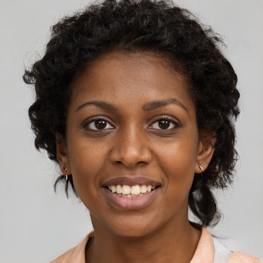 Joyful black young-adult female with long  black hair and brown eyes