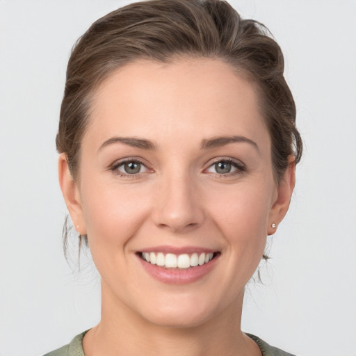 Joyful white young-adult female with medium  brown hair and grey eyes