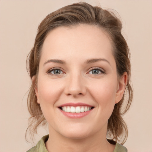 Joyful white young-adult female with medium  brown hair and green eyes