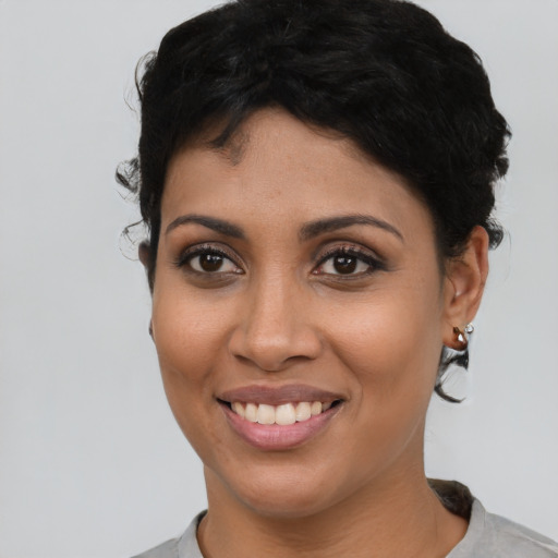 Joyful latino young-adult female with short  black hair and brown eyes