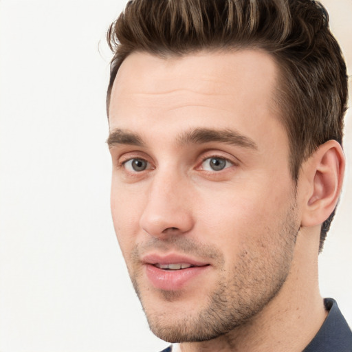 Joyful white young-adult male with short  brown hair and grey eyes