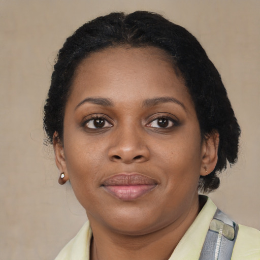 Joyful black young-adult female with short  brown hair and brown eyes