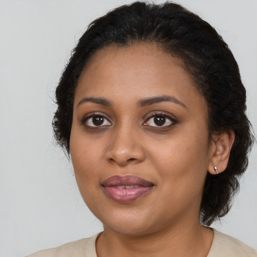 Joyful black young-adult female with long  brown hair and brown eyes
