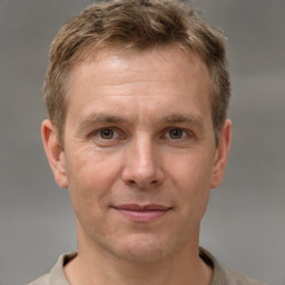 Joyful white adult male with short  brown hair and grey eyes