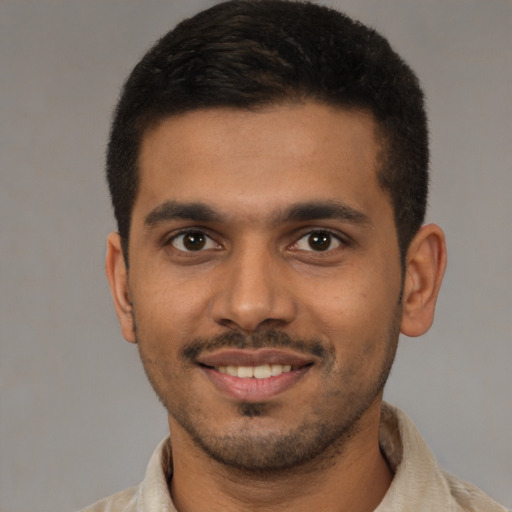 Joyful latino young-adult male with short  brown hair and brown eyes