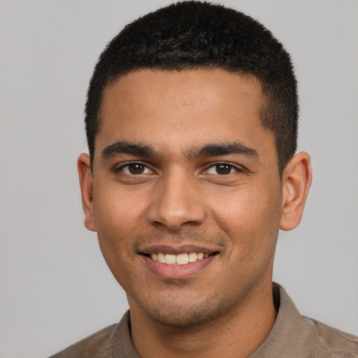 Joyful latino young-adult male with short  brown hair and brown eyes