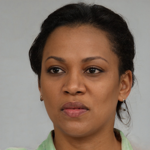Joyful black young-adult female with medium  brown hair and brown eyes