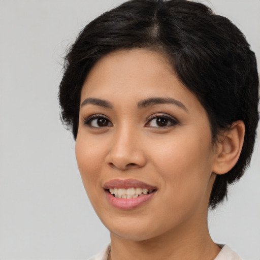 Joyful latino young-adult female with medium  brown hair and brown eyes