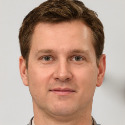 Joyful white adult male with short  brown hair and grey eyes