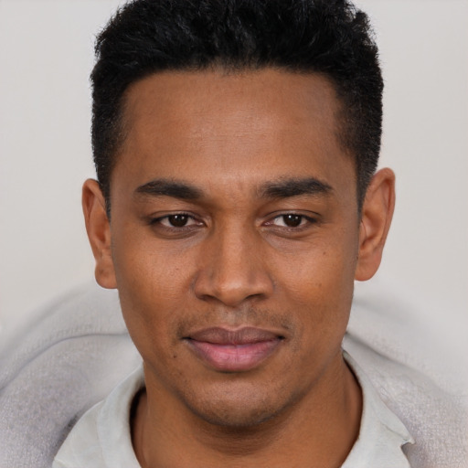 Joyful latino young-adult male with short  black hair and brown eyes