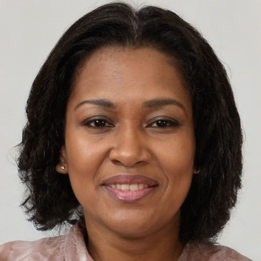 Joyful black adult female with medium  brown hair and brown eyes