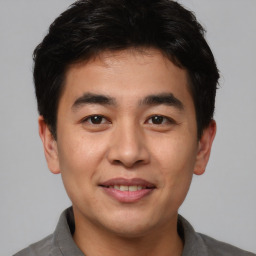 Joyful asian young-adult male with short  brown hair and brown eyes