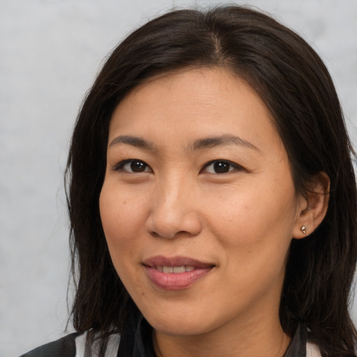 Joyful asian young-adult female with long  brown hair and brown eyes