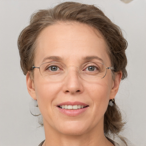 Joyful white adult female with medium  brown hair and grey eyes