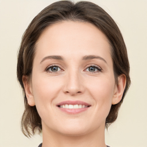 Joyful white young-adult female with medium  brown hair and green eyes