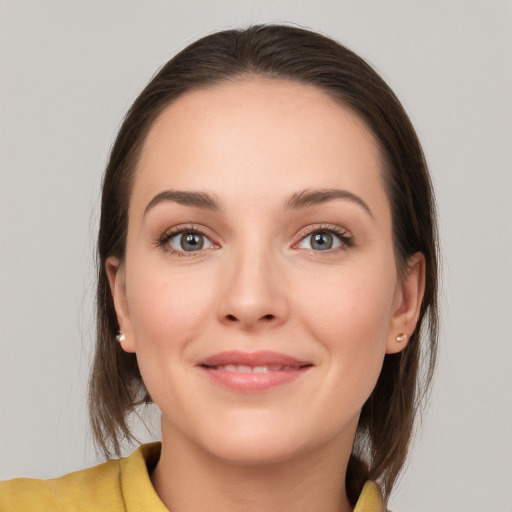 Joyful white young-adult female with medium  brown hair and grey eyes