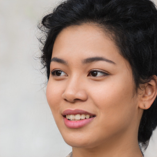 Joyful asian young-adult female with long  black hair and brown eyes