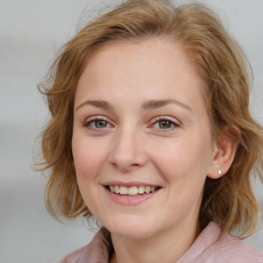 Joyful white young-adult female with medium  brown hair and blue eyes