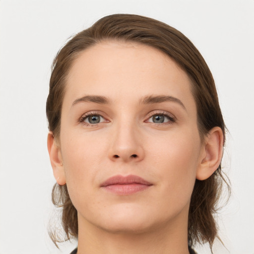 Joyful white young-adult female with medium  brown hair and grey eyes