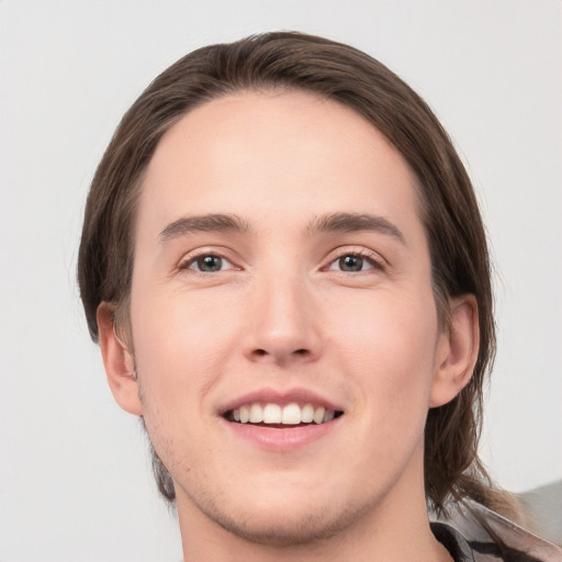 Joyful white young-adult male with medium  brown hair and grey eyes