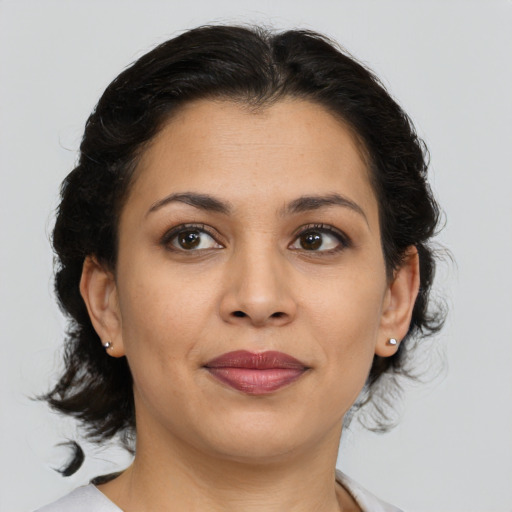 Joyful latino young-adult female with medium  brown hair and brown eyes