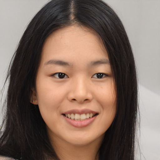 Joyful asian young-adult female with long  brown hair and brown eyes