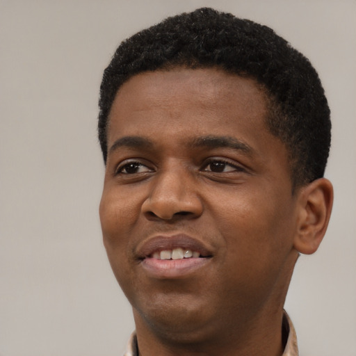 Joyful black young-adult male with short  black hair and brown eyes