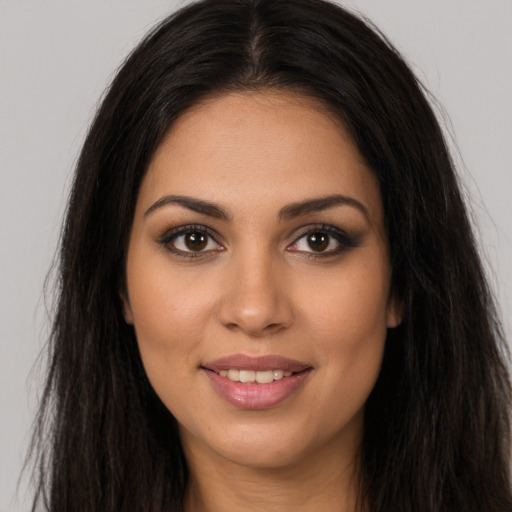 Joyful latino young-adult female with long  brown hair and brown eyes