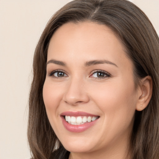 Joyful white young-adult female with long  brown hair and brown eyes