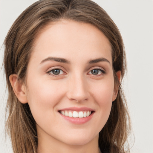 Joyful white young-adult female with long  brown hair and grey eyes